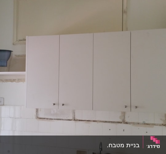 ארון מטבח לבן עם מדף וקנקן מים